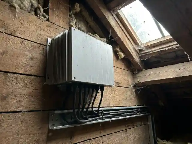 Omvormer aan de muur van een zolder met kabelgoot